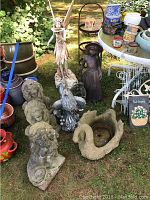Group shot showing all garden sculptures including fairy, girl, lions, bird, swan planter on grass