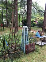 Wide view of lot showing rusted obelisk, blue obelisk, trellis panels and red slat panel