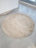 Full view of round beige high-pile rug