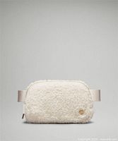 Front view of Lululemon fleece belt bag showing logo medallion and strap ends