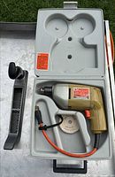 Drill in open case with buffing wheel and rasp plane visible