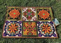 Full view of tapestry laid flat on grass showing entire design and accessories