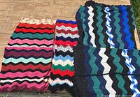 All three chevron crochet afghans laid flat showing full patterns and colors