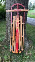 Front view of full sled leaning against tree showing graphics and overall condition