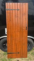 Front view showing entire barn door with vertical planks and hardware