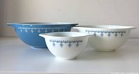 Three Pyrex Snowflake mixing bowls side by side showing pattern and sizes
