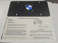 BMW black vanity plate with logo and instruction sheet