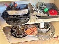 Overview of shelves showing cake pans, mixing bowls, cookbook and accessories