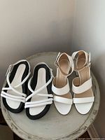Both pairs of sandals side by side on table showing styles and condition