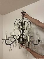 Full view of chandelier showing arms, sockets, and crystal prisms