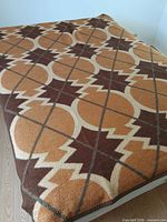 Full view of bedspread laid on bed showing primary brown/tan pattern