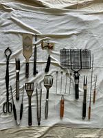 Full layout of approx. 20 barbecue tools on cloth background