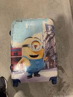 Front of Minion suitcase showing main graphic and wheels