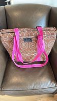 Front view of brown patterned tote with pink straps and SCOUT label