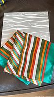 Scarf draped over Simpsons box showing stripe pattern and colours