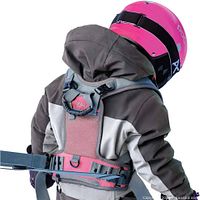Child model wearing grey and pink Sklon harness demonstrating fit and grab handle
