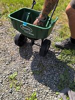 Overall view of Scotts SpeedyGreen 1000 broadcast spreader being pushed on gravel