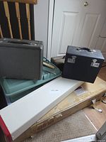 Overall view showing Singer and Elna cases, knitting machine box, totes