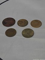 Group shot of five tokens showing both brass and bronze finishes