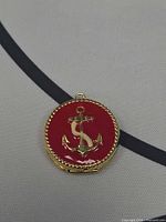 Front view showing red enamel face with gold anchor motif and rope border