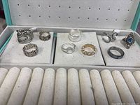 Overview of six rings arranged in jewelry box