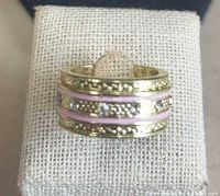 front view of gold-tone multi-row ring displaying pink enamel stripes and rhinestones