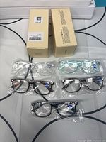 Overview of multiple sealed glasses pairs with two boxes