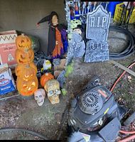 Overall lot showing stacked pumpkins, witch, tombstones, fences, skulls, fog machine