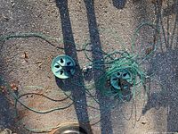 Overhead view of two green reel housings with green clothesline spread on pavement