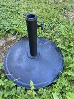 Top view of black concrete and metal umbrella base with center pole