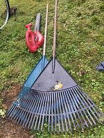 Homelite blower and two poly leaf rakes on grass
