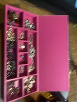 open organizer showing assorted jewellery pieces in compartments