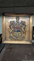 Front of square heraldic bronze plaque with enamelled shield and lions