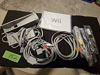 All accessories laid out: power adapter, AV cable, stand, manual, sensor bar