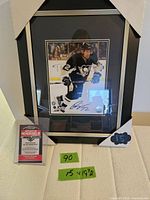 Front view of framed autographed photo with COA card and size note