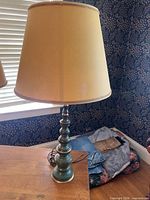 Full view of green metal table lamp with shade