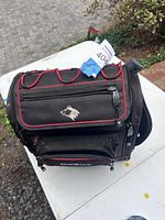 Overall view of black canvas tool bag with red trim and wolf logo