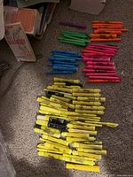 Grouped piles of yellow, pink, orange, green and blue highlighters on carpet