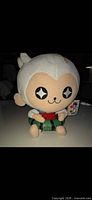 Front view of SEGA Frente white monkey plush showing star eyes, clothing colors, tag visible