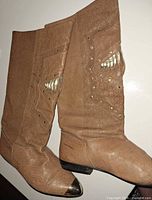 Side view of both boots showing texture, metal toe caps, heel height