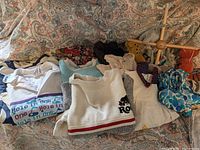 Overall view of clothing, swimwear and baby mobile in lot