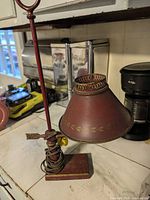 Full view of burgundy metal desk lamp on countertop