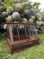 front angled view showing wood frame, glass panes, metal arches, crest