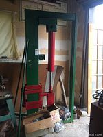 Full view of green Dayton log splitter frame with red hydraulic cylinder and wedge