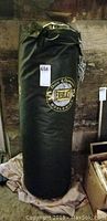 Full view of the black Everlast punching bag standing upright showing size and condition.