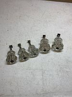 Five clear faceted glass drawer pulls laid out showing fronts and stems