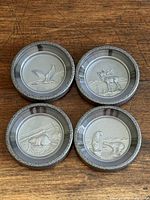 Top view of all four coasters showing different wildlife reliefs