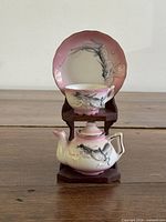 Full view of teapot, cup, saucer on stand