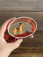 Front angled view showing greyhound figurine, flowers, lucite case and metal feet