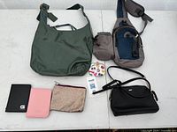 All seven items laid out: Coach purse, DKNY purse, sling bag, two passport wallets, glitter pouch, floral coin purse